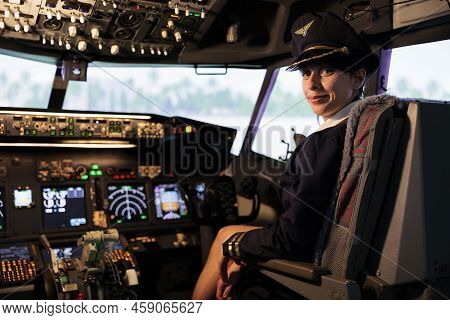 Portrait Of Woman Copilot In Uniform Flying Airplane Jet From Cockpit With Control Panel Command And
