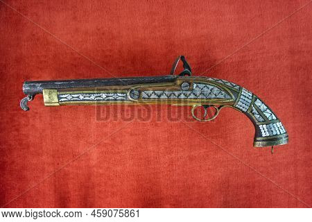 Ancient Vintage Wooden Gun On A Red Background