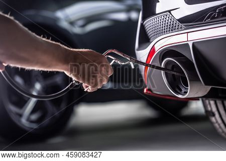 Measurement Of Exhaust Emissions At The Technical Inspection Station. A Car Repairman Applies A Prob