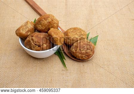 Closeup Of Organic Sweet Palm Jaggery With Leaves Isolated On Burlap Fabric In Horizontal Orientatio