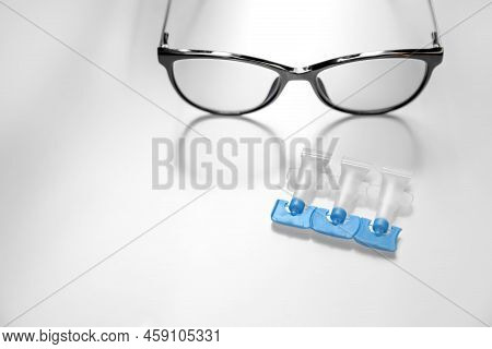 Single Dose Eye Drops And Glasses On White Table, Space For Text