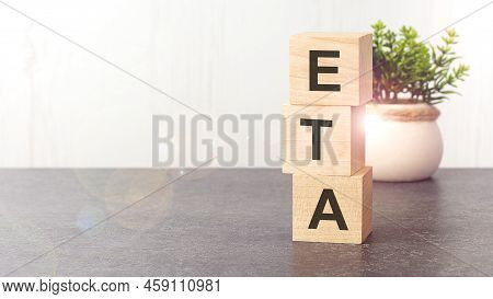 Text Eta On Wooden Dice Standing On Top Of Each Other, Gray Background. Eta - Estimated Time Of Ariv