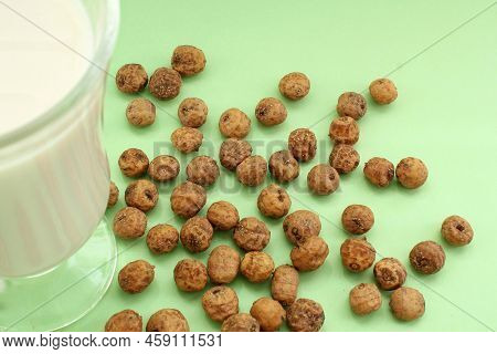 Top View Of Chufa Nuts, Tigernut, Earth Almond, Groundnut On Green Background And Defocused Glass Cu