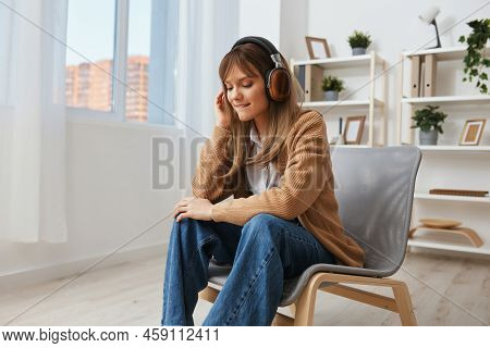 Enjoyed Free Time Young Blonde Student Lady Freelancer In Warm Sweater In Headphones Listen Fav Song