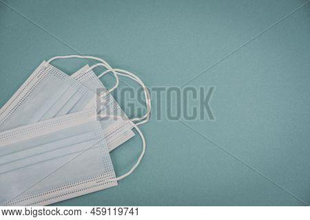 Tipical Surgical Masks With Rubber Ear Straps On Blue Background, Top View . Protection Concept.