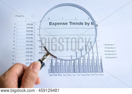 Holding Magnifying Glass On Expense Trends Chart. Inflation Or Cost Of Living Concept.