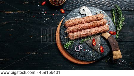Raw Lula Kebab On Skewers With Spices On A Cutting Board Light Background. Lula Kebab, Traditional C