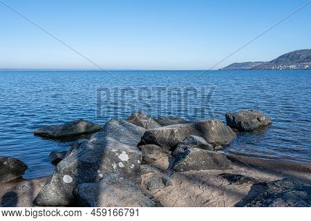 Boulders As A Part Of A Wave Breaker In A Lake. Picture From Lake Vattern, Sweden. Blue Water And Sk