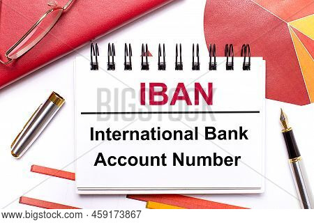 On The Desktop Is A White Notebook With The Text Iban International Bank Account Number, A Pen, Burg