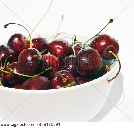 Cherry In A Bowl On A White Background. The Photo Shows Cherries In A Bowl On A White Background, Ma
