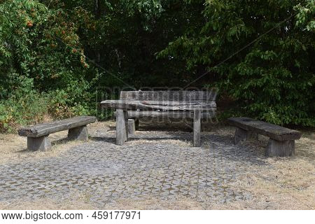Park Benches Around A Table, All Made Of Wood And Very Weathered