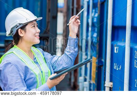 Asian Young Teen Working In Shipping Logistic Cargo Load Area Use Tablet Wireless Technology To Chec
