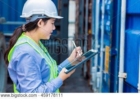 Asian Young Teen Working In Shipping Logistic Cargo Load Area Use Tablet Wireless Technology To Chec