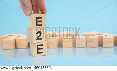 Hand Holding Wood Cube Block With Text E2e - Exchange To Exchange. The Inscription On The Cubes Is R
