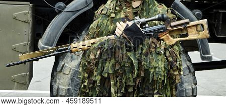 Close-up Portrait Of A Military Sniper In Camouflage Green Army Clothes With A Degtyarev Sniper Rifl