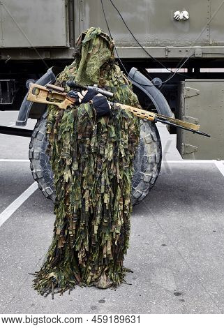 Close-up Portrait Of A Military Sniper In Camouflage Green Army Clothes With A Degtyarev Sniper Rifl