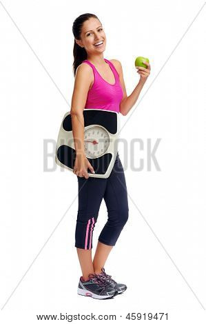 หญิงรับประทานอาหารเพื่อสุขภาพ ด้วยสเกลและแอปเปิ้ลสำหรับ weightloss