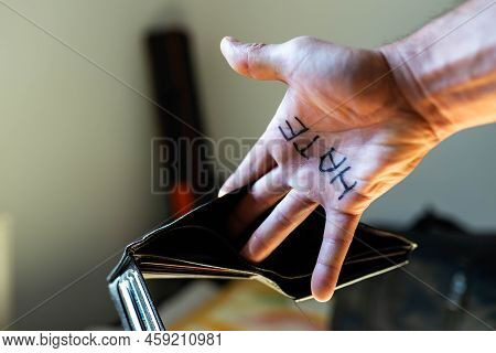 Caucasian Man Showing Hes Empty Wallet, The Word Hate Is Written On Hes Palm, Conceptual Image Of Un