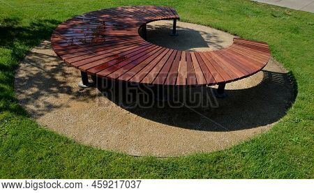 Circular Bench Made Of Brown-red Teak Wood. Tropical Impregnated Podia Boards For Sunbathing Visitor