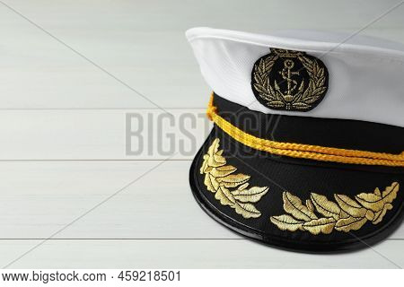 Peaked Cap With Accessories On White Wooden Background, Closeup. Space For Text