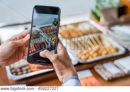 Hand Taking Photo Of A Food Stall And Make A Video