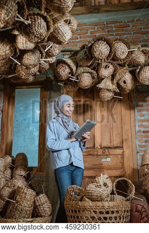 Female Entrepreneur In Hijab Smiling While Using Tablet