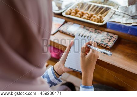 Muslim Woman Write Customers Order On A Small Note
