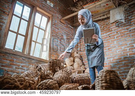 Craftswoman In Veil Holding Pad Checking Water Hyacinth Woven Crafts