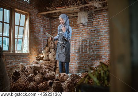 Craftswoman In Veil Checking Water Hyacinth Woven Crafts