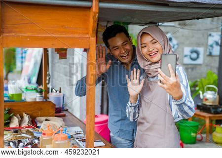 Muslim Friend Standing At Their Food Stall And Make A Video Call