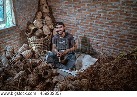 Top View Of A Water Hyacinth Craftsman Sitting And Smiling