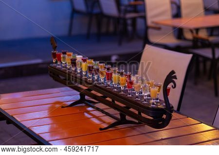 Glass Stacks Are Filled With Different Drinks As An Advertisement In A Drinking Establishment, A Bar