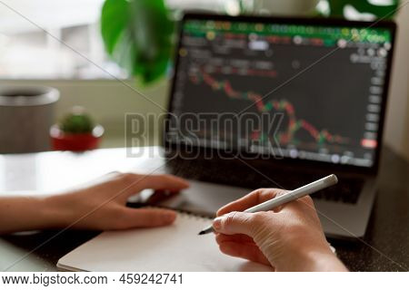 Female Hands Writing Down Numbers From Laptop. Investment Analysis, Trading Concept. Technology, Dig