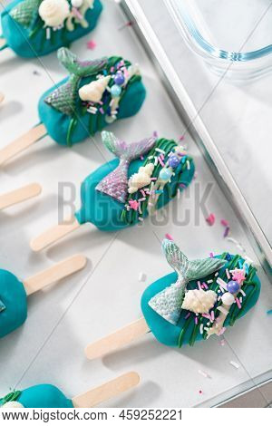 Mermaid Cakesicles With Drizzled Chocolate, Chocolate Mermaid Tails, Seashells, And Sprinkles.