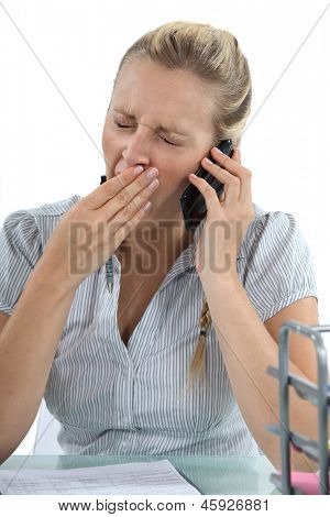 Frau am Telefon und gähnen
