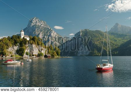 Scenic View On The Perched Johannesberg Chapel In Austria, Surrounded By Mountains And The Lake Trau
