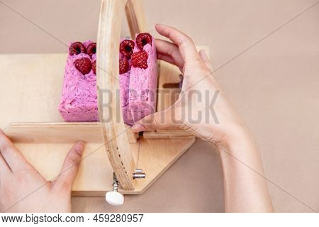 A Soap Maker Cuts Multi-colored Pieces Of Soap On A Special Wooden Device. View From Above. Only Han