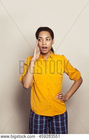 Young Beautiful Surprised African American Woman Wearing Casual Yellow Shirt Standing On White Backg