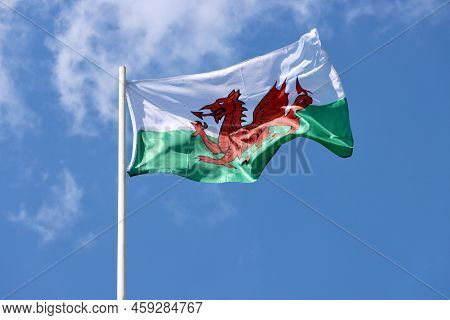 Wales Flag - Red Dragon Passant On White And Green - Bold And Proud Floating In The Wind Against Blu