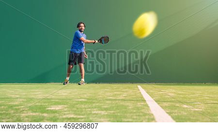 Padel Player With Black Racket Playing A Match In The Open Behind The Net Court