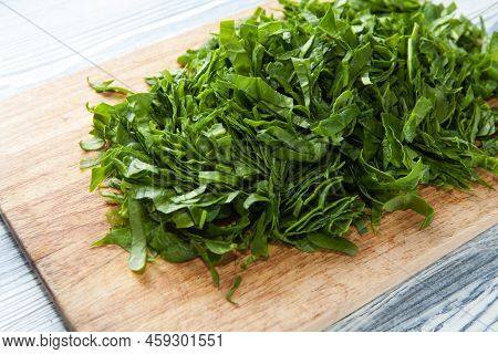 Chopped Spinach On A Wooden Cutting Board. Dietary Nutrition. Close-up, Selective Focus.