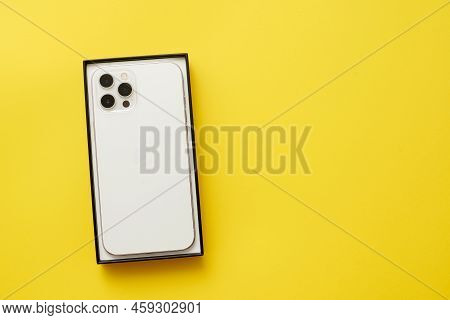 Stariy Oskol, Russia - July 5, 2021: New Smartphone From Apple Iphone In Box On Yellow Background