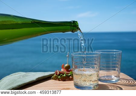 Pouring Of Txakoli Or Chacolí Slightly Sparkling Very Dry White Wine Produced In The Spanish Basque