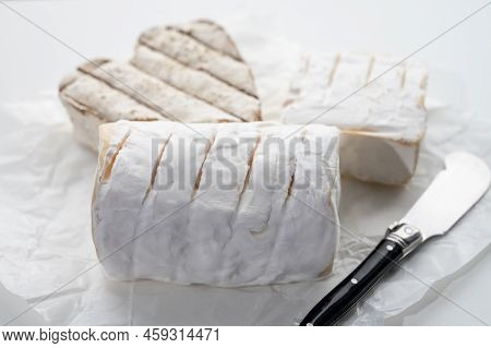 French Cheeses Heartshaped, Squared And Cylindrical Neufchatel Cow Cheese With Mold On White Paper,