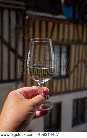 Tasting Of White Grand Cru Classe Chablis Wine With Old French Houses On Background, Burgundy, Franc