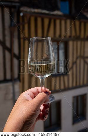 Tasting Of White Grand Cru Classe Chablis Wine With Old French Houses On Background, Burgundy, Franc