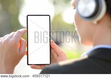 Back View Close Upportrait Of An Executive With Wireless Headphones Checking Blank Smart Phone Scree