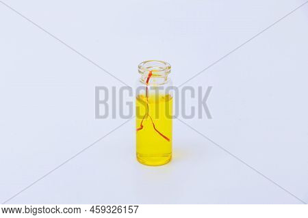 Saffron Drink In A Small Jar On A White Background. Red Stamens In The Drink.