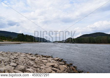 Rhine With Ship And Heavy Clouds Hanging Over The Wide Blue River