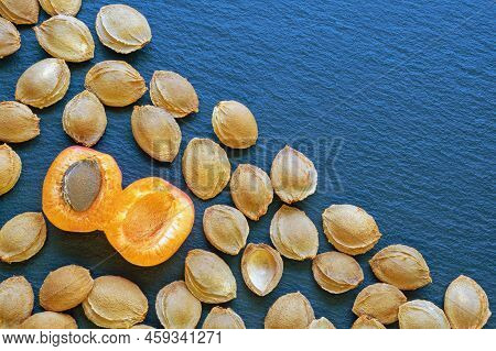 Apricot Stones On Dark Rustic Table. Flat Lay, Copy Space